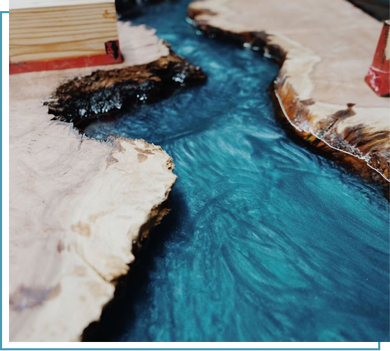 Image of Ecopoxy casting resin being used to make a table with a blue river through it